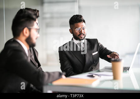 Portrait of three co-workers discussing business plan in office Stock Photo
