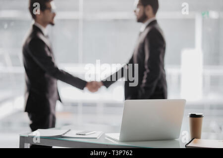 Two business people shaking hands in office as sign of partnership Stock Photo