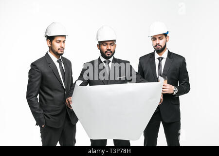 Three indian businessmen architect in the construction helmets standing isolated on white background Stock Photo