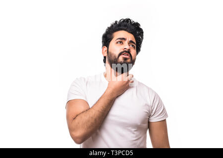 Young man having sore throat and touching his neck, wearing a loose white t-shirt against light grey background. Hard to swallow Stock Photo