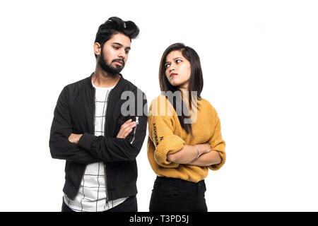 Beautiful indian couple standing apart from each other while being in a quarrel on white background. Stock Photo