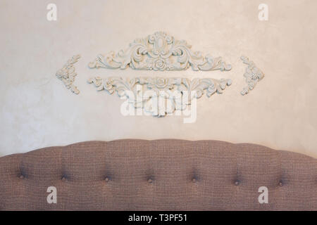 Expensive interior. Stucco elements on light luxury wall. White patterned. Mouldings element from gypsum. Roccoco style. Stock Photo