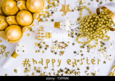 Luxury easter celebration concept, top view of golden items used to celebrate festivity  on a white background  with an hashtag celebrating the happy  Stock Photo