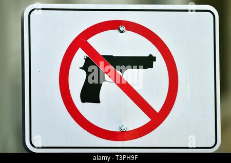 Geneva, Illinois, USA. A warning sign indicating no guns allowed on display at a parking lot near a county courthouse.