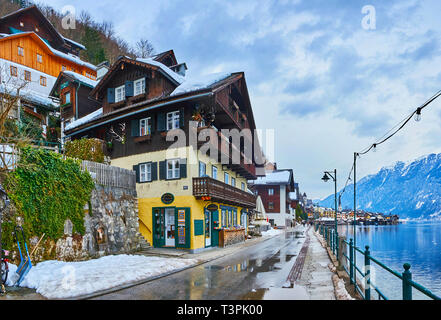 HALLSTATT, AUSTRIA - FEBRUARY 21, 2019: Seestrasse stretches along the bank of Hallstatter see (lake) and boasts large amount of tourist stores, cafes Stock Photo