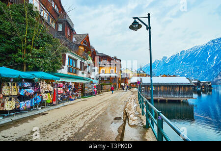 HALLSTATT, AUSTRIA - FEBRUARY 21, 2019: Stalls of the tourist market on embankment of small tourist town, located on slope of Salzberg, famous for the Stock Photo