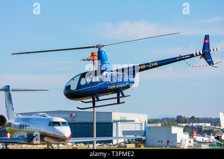 A Robinson R44 Raven II helicopter landing at Zurich airport Stock Photo