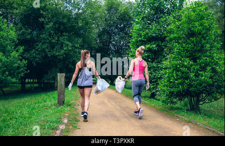 Two girls on back doing plogging Stock Photo