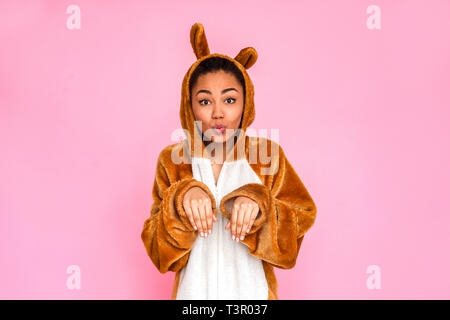 Young woman in bunny kigurumi standing isolated on pink background posing to camera pouting lips cute Stock Photo