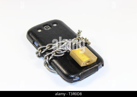 Smartphone locked with a chain and a lock - isolated Stock Photo