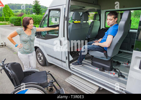 Handicapped boy is picked up by school bus Stock Photo