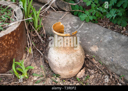broken old jug on the ground thrown out utensils Stock Photo