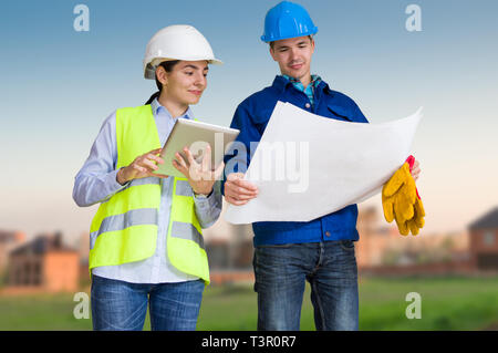 Foreman and student with blueprints at construction site Stock Photo