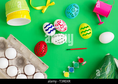 Flat lay top view colorful easter egg painted in green background and mock up blank notebook with paint brush. Easter day background top view with copy space Stock Photo