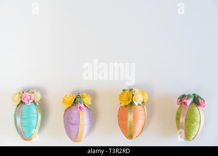 Row of vintage style multi-colored Easter eggs on sold white background Stock Photo