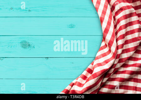 Red checkered fabric on blue wood table background.For decoration key visual layout Stock Photo