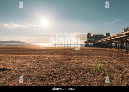 Weston-super-Mare, North Somerset, England, UK - October 04, 2018: The setting sun over the beach and the Grand Pier