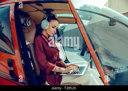 Focused appealing woman with tied hair wearing red shirt Stock Photo