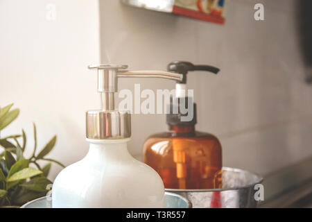 Two soap dispensers in a light room with natural sunlight. Cleaning and hygiene concept Stock Photo