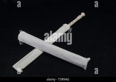 Standing on a black background, a white-colored instrument instruments flute wind intsrument Stock Photo