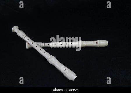 Standing on a black background, a white-colored instrument instruments flute wind intsrument Stock Photo