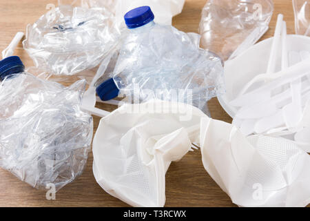Disposable waste plastic on wooden background. Stock Photo
