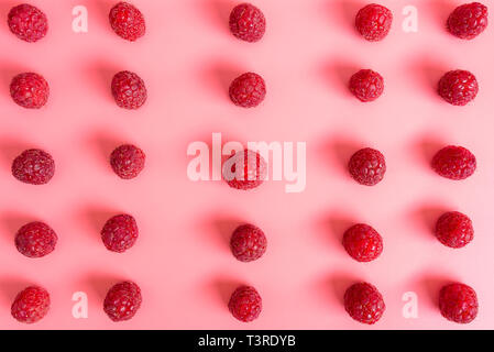Pattern made from fresh raspberries, top view, flat lay pattern, isolated on a light pink background. Stock Photo