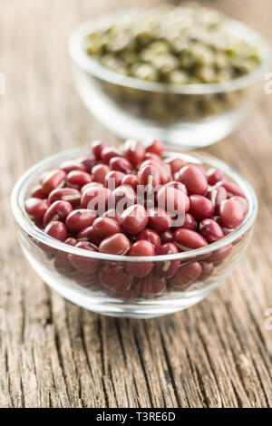 Red adzuki beans in bowl on wooden table. Stock Photo
