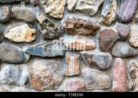 Weathered grunge rough stone wall as background texture close up Stock Photo