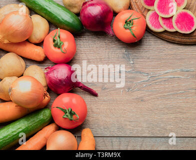 Set of fresh vegetables for the preparation of tasty and healthy food on a wooden table. Stock Photo