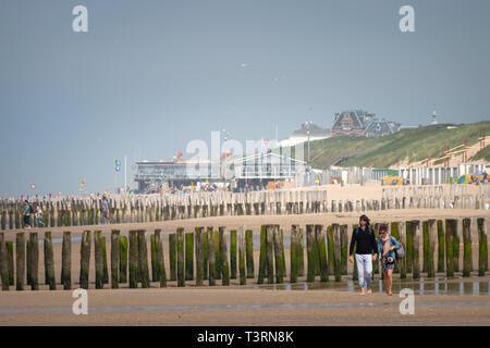 Domburg, the Netherlands – June 9, 2018: People walking along North Sea beach in Domburg, Zeeland, the Netherlands on a hazy day Stock Photo