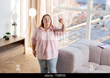 Positive plump woman smiling into the camera Stock Photo