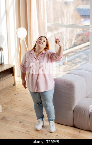 Top view of a joyful plump woman taking photos Stock Photo