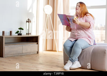 Nice plump woman eating a tasty banana Stock Photo