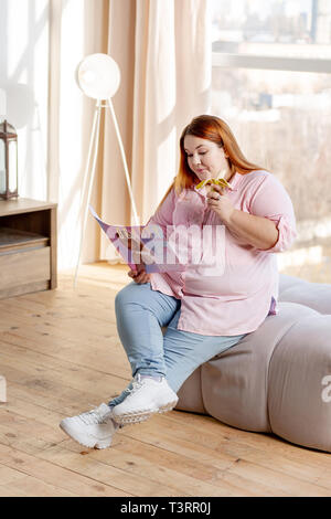 Positive nice woman reading an article about beauty