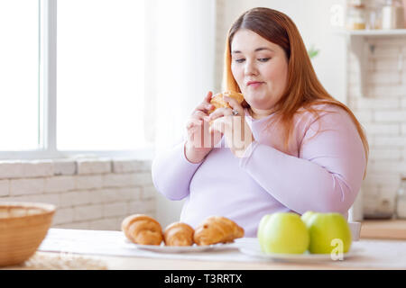 Nice thoughtful woman looking at the apple Stock Photo