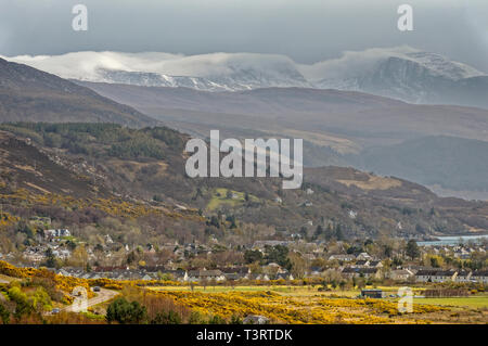 ULLAPOOL ROSS AND CROMARTY SCOTLAND THE TOWN IN EARLY SPRING WITH SNOW AND CLOUDS OVER THE BEINN DEARG MOUNTAINS Stock Photo