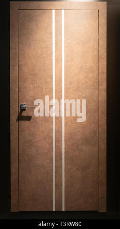 closed room door in brown color with two thin white stripes in dim light Stock Photo