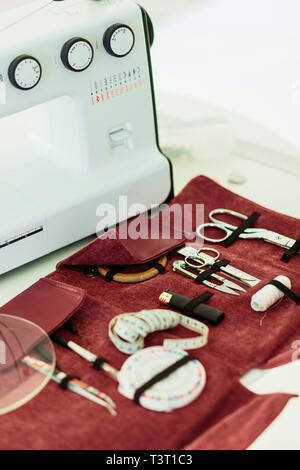 sewing kit accessories in pink cover and machine on the table Stock Photo