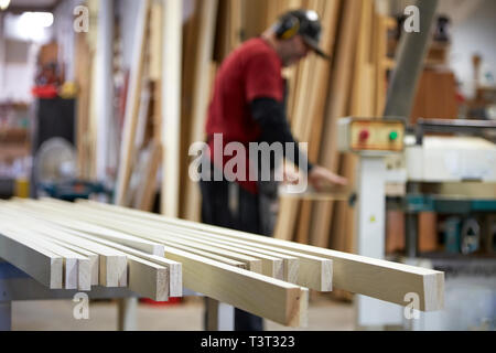 Carpenter using saw in workshop Stock Photo