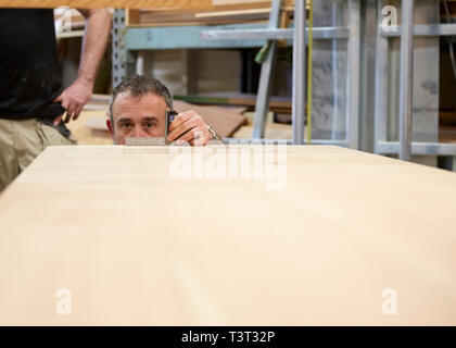 Carpenter measuring wood in workshop Stock Photo