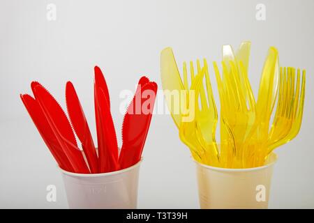 Red and yellow plastic cutlery in plastic cups, plastic knives, plastic forks, plastic waste, Germany Stock Photo