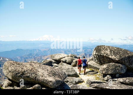 Couple hiking on rocky hilltop Stock Photo