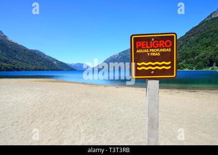 Sandy beach beach with warning sign, Attention deep and cold water, Lago Traful, Province Neuquen, Patagonia, Argentina Stock Photo