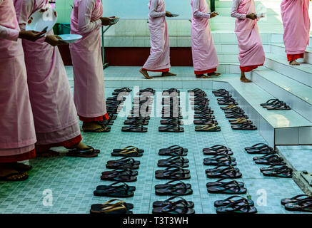 Monks leaving sandals near staircase Stock Photo