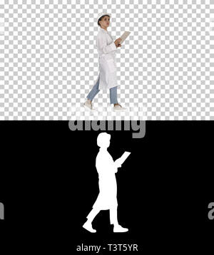 Young technician inspecting and taking necessary notes on digital tablet, Alpha Channel Stock Photo