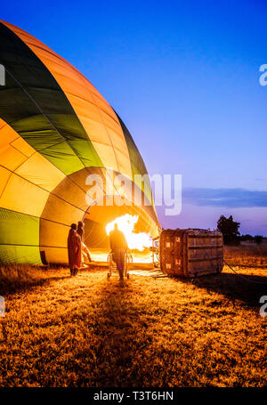 Hot air balloon inflating in rural field Stock Photo