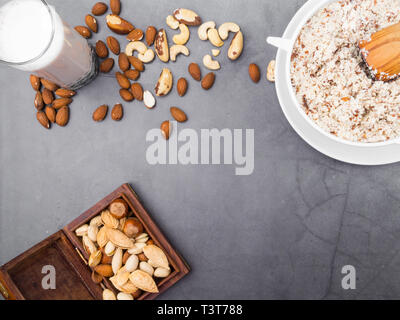 Vegan milk from nuts in glass jar with various nuts on grey background, nuts in wooden box, copy space Stock Photo