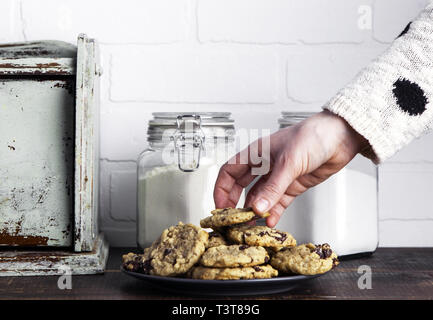 Hand taking cookie from plate Stock Photo
