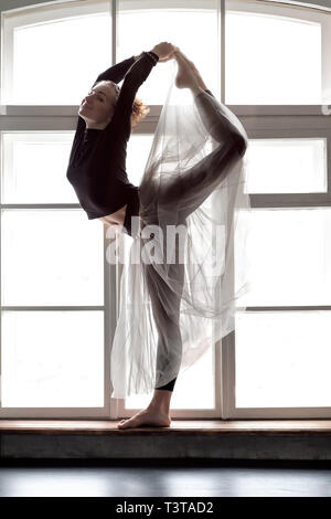 Woman practicing yoga, doing Natarajasana exercise, Lord of the Dance pose Stock Photo